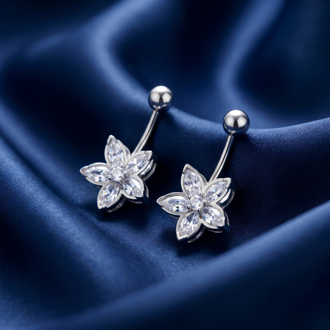 Flower-shaped silver earrings on a dark blue satin background